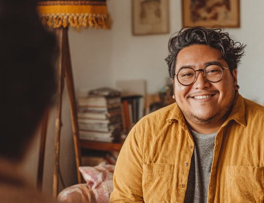 Two people in a warm therapy conversation in a cozy home office